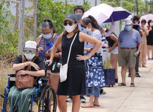 Local residents stand in line to receive food at a distribution event held at the Na Kupuna Makamae Center, in Honolulu, HI, Friday, May 15, 2020. The center normally runs programs and services for seniors and since the COVID outbreak has become home for a weekly food distribution project made available by a partnership between the Pacific Gateway Center, Aloha Harvest, and Help is on the Way organizations. (Ronen Zilberman photo Civil Beat)