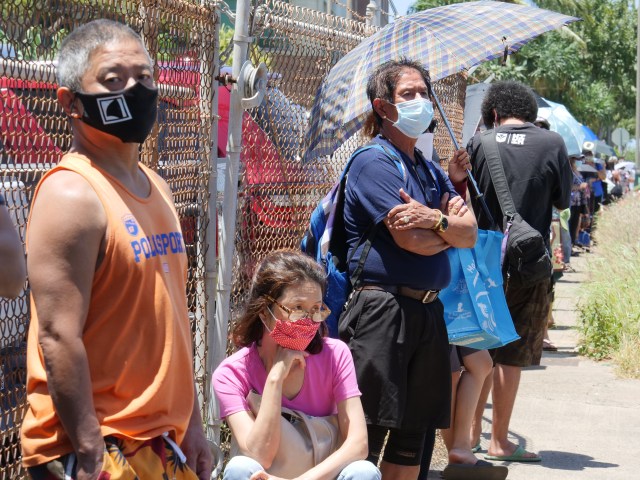 Local residents waited patiently in a long line that wrapped around the block to receive food at a distribution event by the Na Kupuna Makamae Center, in Honolulu, HI, Friday, May 8, 2020. The weekly project is the result of a partnership between the Pacific Gateway Center, Aloha Harvest, and Help is on the Way organizations. (Ronen Zilberman photo Civil Beat)