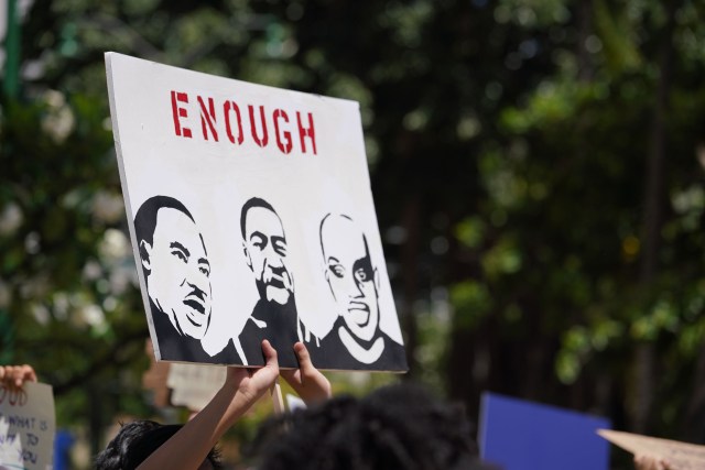 Demonstrators hold signs during Black Lives matter Peaceful Protest at the Duke Kahanamoku statue. Supporters marched from Ala Moana Beach park to the statue.