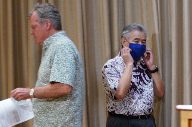 Governor David Ige walks toward podium as Dr Bruce Anderson heads back to sit down during press conference held during COVID-19 pandemic. June 15, 2020