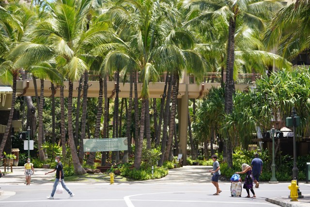 Backdrop of coconut trees at Royal Hawaiian Shopping Center, looking makai on Seaside Avenue, very little foot traffic in Waikiki during COVID-19 pandemic. June 17, 2020