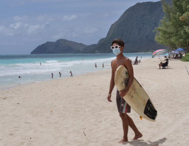 Koa Yokota arrives to the beach with his short board and COVID mask to catch some waves in Waimanalo, HI, on Sunday, July 12, 2020. (Ronen Zilberman photo Civil Beat)