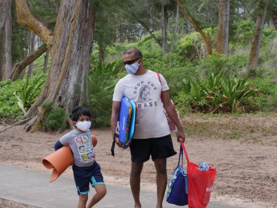 On the Windward side of Oahu, Suketu Naik and his son Agam Keral head to the beach with their protective masks in Waimanalo, HI, Sunday, July 12, 2020. (Ronen Zilberman photo Civil Beat)