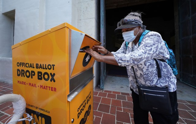 Kakaako resident Saidah Hatchett places her vote by mail envelope/ballot into a official ballot drop box located at Honolulu Hale. July 22, 2020.