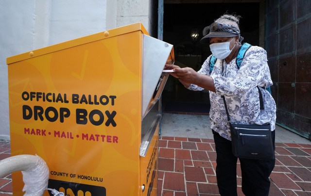 Kakaako resident Saidah Hatchett places her ballot into the ‘Officlal Ballot Drop Box’ fronting Honolulu Hale. July 22, 2020