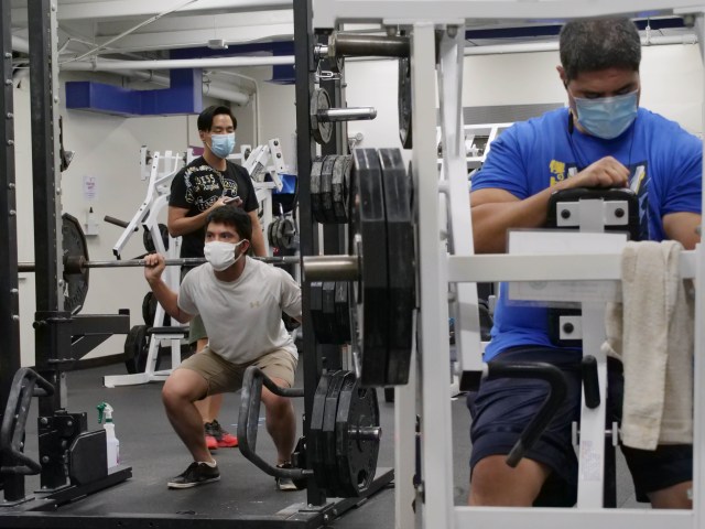 Rory Fraitaf (right) prepares to use a weight machine while others lift free weights behind him at the Nu'unau YMCA in Honolulu, HI, Thursday, July 30, 2020. Fraitaf says he comes to the gym everyday to exercise. (Ronen Zilberman photo Civil Beat)