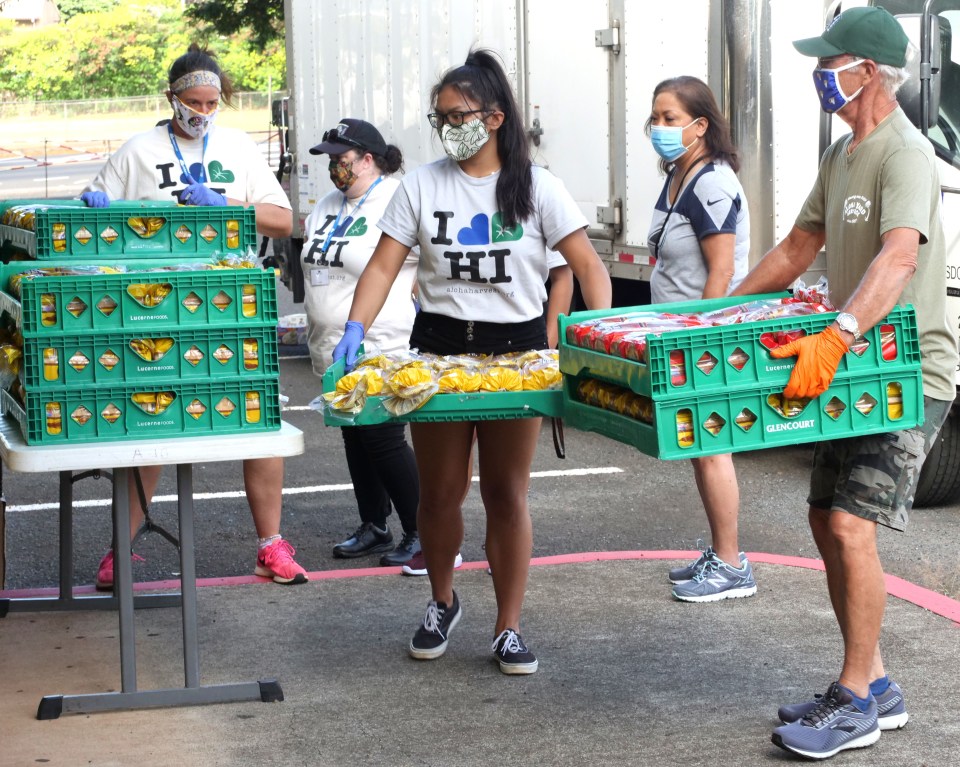 Volunteers organize bins of bread to be given out during a food distribution event held at Aiea High School on Friday, July 10, 2020. The HLTA (Hawaii Lodging &amp; Tourism Association) and Aloha Harvest collaborated with the City of Honolulu to put on the event. (Ronen Zilberman photo Civil Beat)