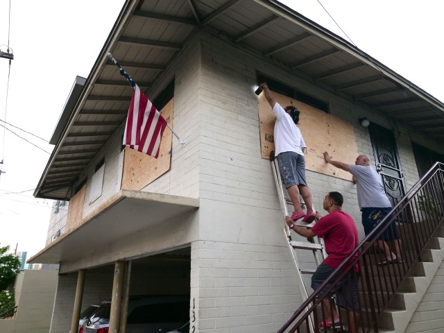 From left to right, Mapu Obrien, Jack Obrien, and Masta Obrien board up the windows to their home in preparation for hurricane Douglas in Honolulu, HI, Saturday, July 25, 2020. (Ronen Zilberman photo Civil Beat)
