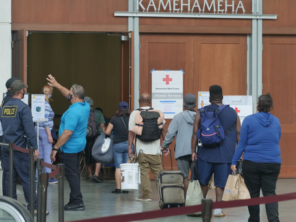 People arrive to shelter at the Hawaii Convention Center in Honolulu, Sunday, July 26, 2020. Oahu began opening up storm shelters around the island early Sunday morning as Hurricane Douglas forecasters warn of damaging wind, heavy rainfall, and dangerously high surf from the category 1 storm. (Ronen Zilberman photo Civil Beat)