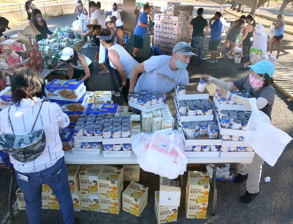 Volunteers from the HLTA (Hawaii Lodging & Tourism Assoc.) and Aloha Harvest organize food donations for a drive-thru distribution event, at Aloha Stadium, Friday, August 14, 2020. The event has prepared 1,000 food bundles for hospitality workers and their families. (Ronen Zilberman photo Civil Beat)