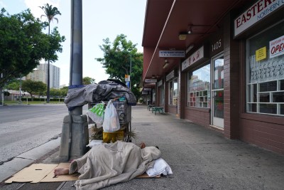 Houseless person sleeps on the sidewalk on King Street near Keeaumoku Street during COVID-19 pandemic. August 23, 2020