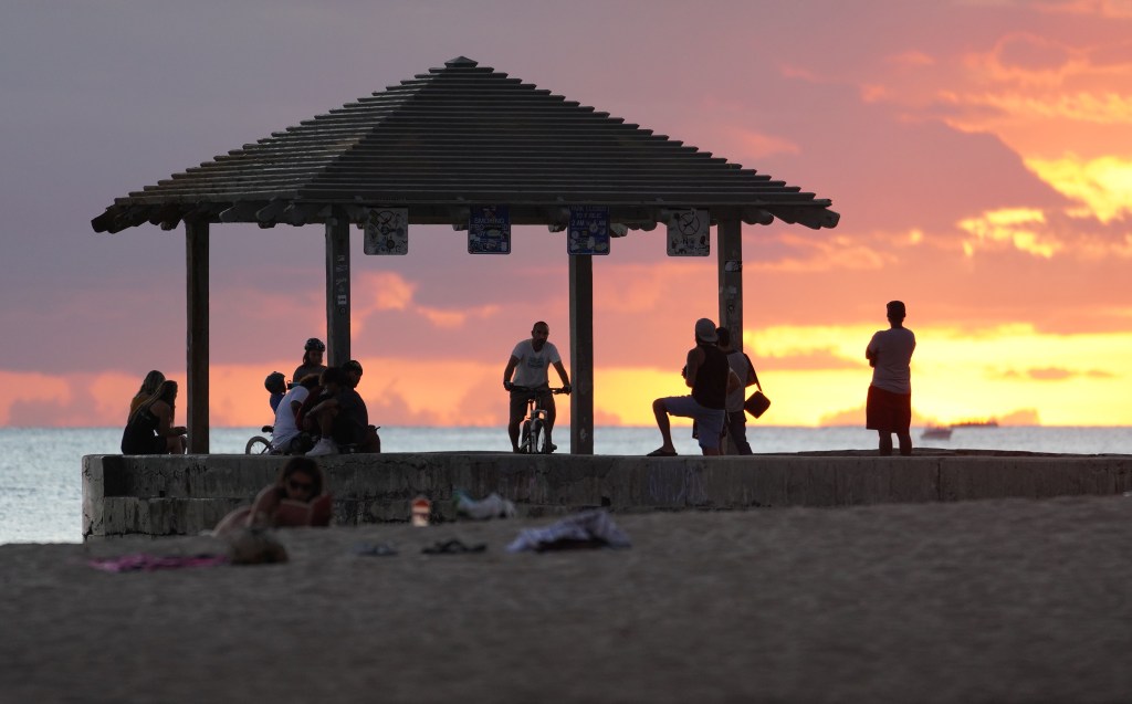 Beautiful sunset with people enjoying the beach and waterfront area along Waikiki Beach and the Kapahulu Groin or ‘Walls’ after Mayor Caldwell reopened beaches and parks on friday. September 13, 2020