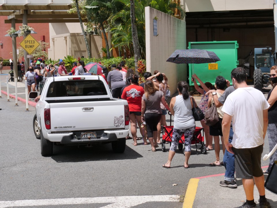 People lined up on foot and by cars to recieve free food at a distribution event put on by  the Hawai’i Health &amp; Harm Reduction Center (H3RC) and the Hawai’i Foodbank, at the Windward mall in Kaneohe, HI, Tuesday, Sept. 8, 2020. (Ronen Zilberman photo Civil Beat)