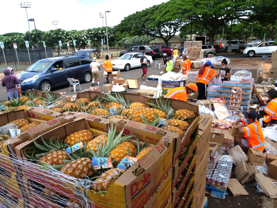 Volunteers pack boxes and load into the trunks of waiting vehicles as they line up to recieve free food packages at a Lighthouse Outreach food distribution event at the Patsy T. Mink Central Oahu Regional Park on Oahu, Friday, Sept. 18, 2020. (Ronen Zilberman photo Civil Beat)