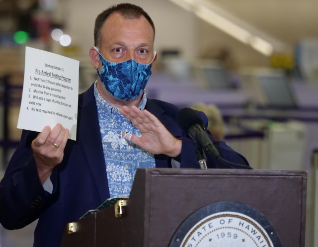 Hawaii Lt. Govenor Josh Green holds a sign detailing traveler safety guidelines during a media briefing Tuesday, Oct. 7, 2020 in Honolulu, HI. The briefing was held to unveil new COVID-19 safety measures the state plans to implement upon opening to travelers on October 15th. (Ronen Zilberman photo Civil Beat)