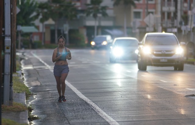 Lone jogger runs on the bikepath/road along South Beretania Street to avoid pedestrians on the sidewalk during the COVID-19 pandemic. October 5, 2020