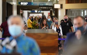 Hundreds of passengers arrive and wait in a line with Governor Ige and Lt. Gorvernor Josh Green in foreground during press conference. Arriving passengers are screened if they have pre-travel testing required to avoid the 14-day traveler quarantine. Tests are only accepted from trusted testing and travel partners. October 15, 2020