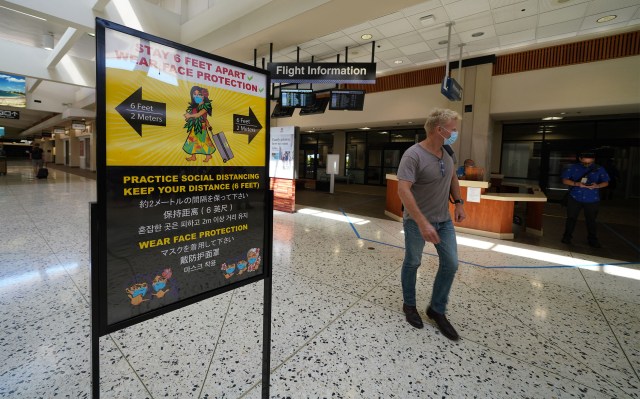 Daniel K. Inouye Airport signs warn to social distance and the wearing of masks during COVID-19 pandemic as Hawaii reopens to transpacific travelers on October 15, 2020