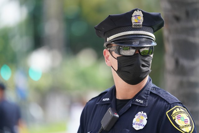 Masked HPD Honolulu Police officer patrols near the Waikiki substation. October 28, 2020