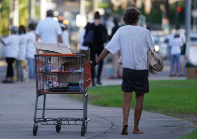 Person pushes their cart with their belongings barefooted fronting the Capitol during COVID-19 pandemic. October 14, 2020
