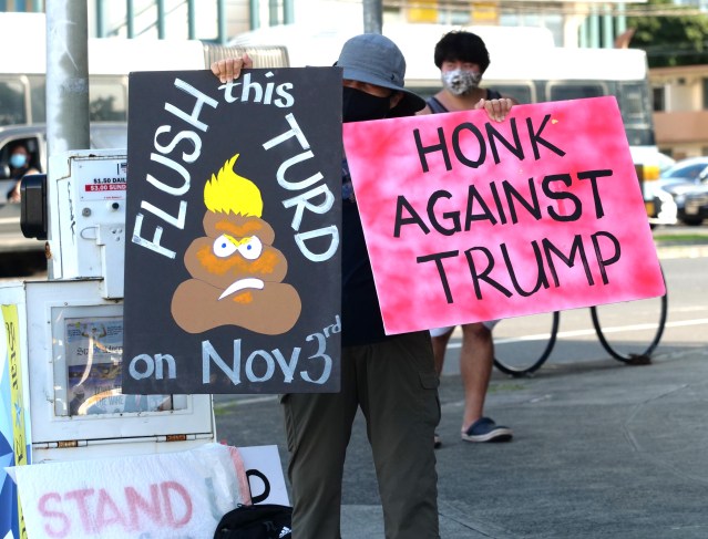 A woman holds up anti-trump signs at the corner of Beretania and University Ave. on the eve of election day Monday, November 2, 2020. (Ronen Zilberman photo Civil Beat)
