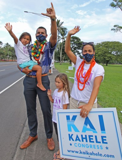 Kai Kahele, candidate for US congress, sign-waves with his wife Maria, daugthers Iolana (6) (standing) and Namaka (4) along Hilo’s Bayfront area. Photo: Tim Wright