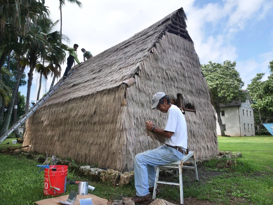Dwight Kauahikaua, seated, Kaspar Carewell, top left, and Earl Kawaa build a hale at the Hawaiian Mission House historic site, in Honolulu, HI, Tuesday, November 3, 2020. (Ronen Zilberman photo Civil Beat)