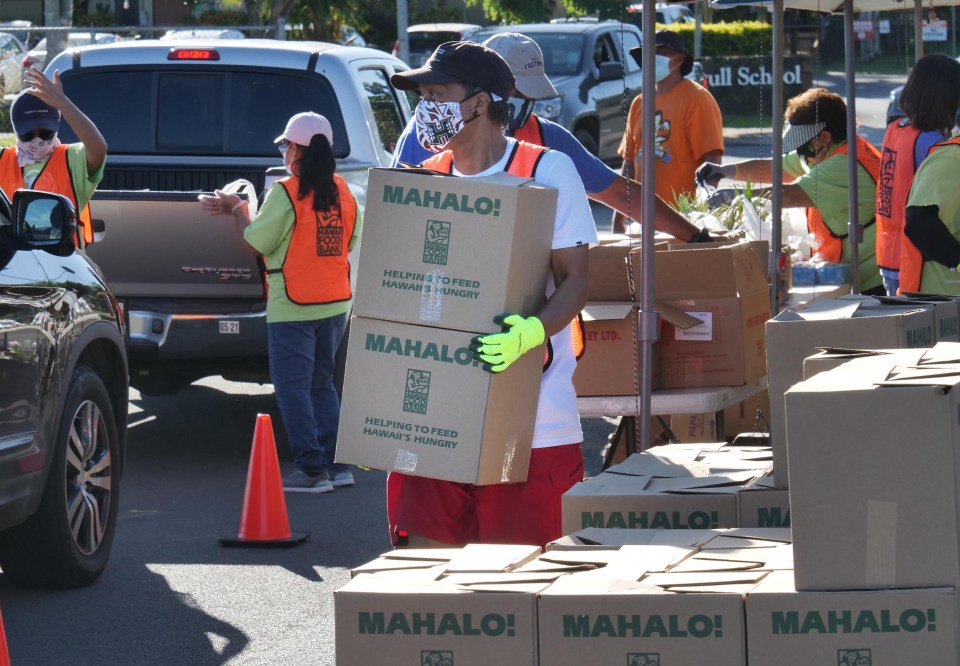 Hawai'i Foodbank volunteer, Jon Fernandez, carries boxes to be loaded into waiting vehicles during a pop-up food distribution event at the 'Ewa Pu'uloa District Park, Wednesday, December 2, 2020. (Ronen Zilberman Civil Beat)
