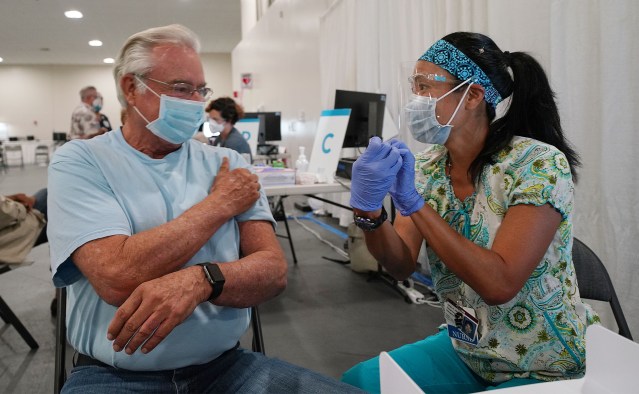 Chuck Reindollar rubs the arm that Registered Nurse Caryn Amii just vaccinated at Pier 2 during the COVID-19 vaccinations. January 18, 2021
