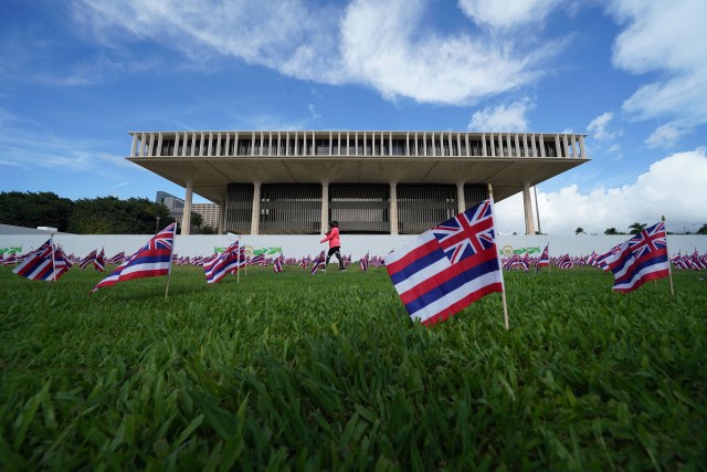 Hawaii State flags blow in the wind on opening day of the 2021 legislature.