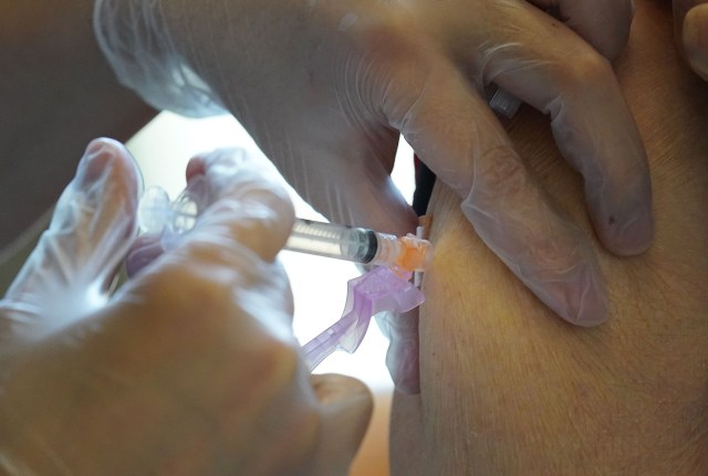 Pharmacist Davis Zheng gives a patient the Moderna COVID-19 vaccine at Craigside Place carehome vaccinations.