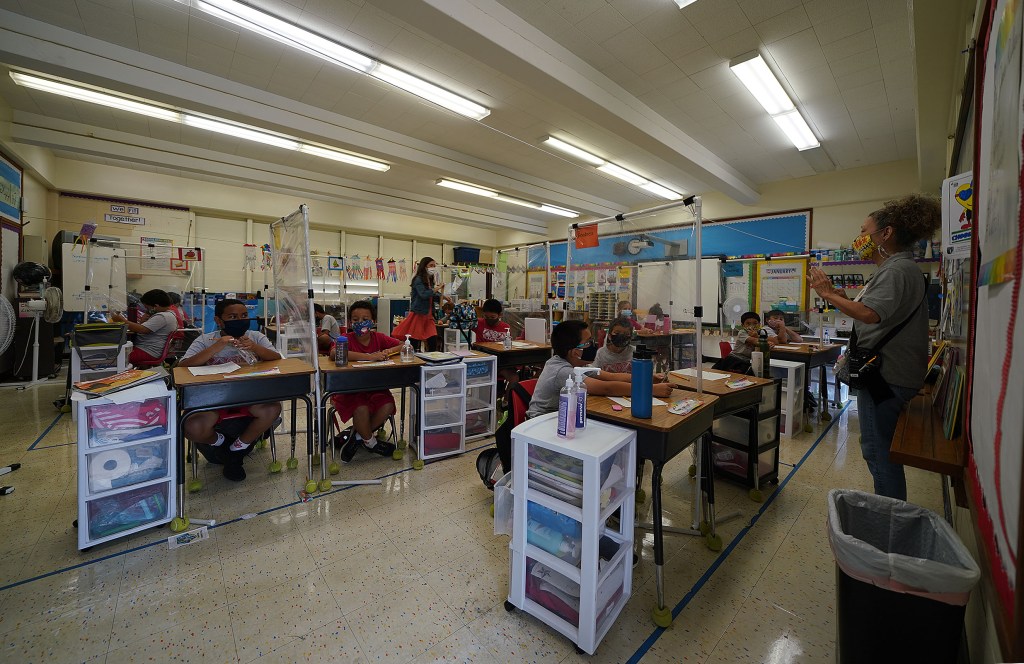 St Ann School students enjoy in person classes with plastic barriers during the COVID-19 pandemic.