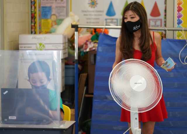 Ala Wai Elementary School teacher Lori Kwee assists 3rd grade student Sano Blailes.