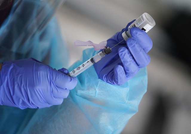 Registered Nurse Alexis Lagasca from Kalihi Palama Health Center fills syringe with Moderna COVID-19 vaccine at St. Elizabeth Church.