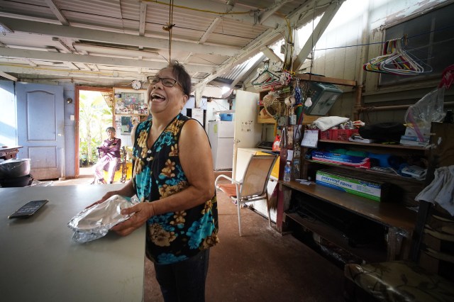 Kunia Village resident Tassie Fagarang smiles as she wraps some fried potatoes in her garage.