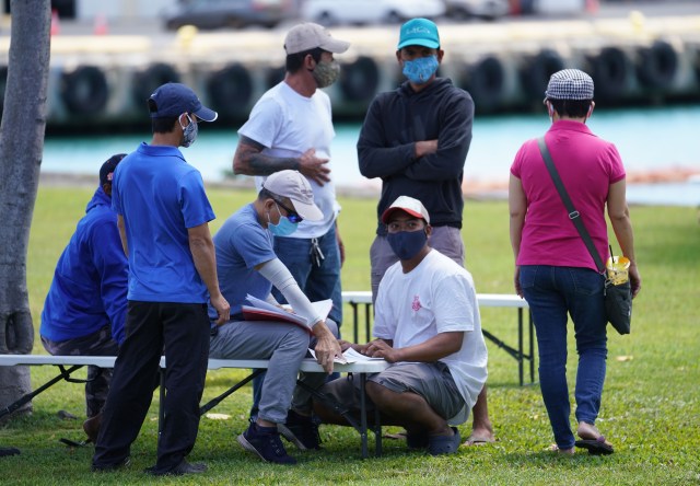 Crews from fishing boats wait to get their COVID-19 vaccinations at Pier 38.