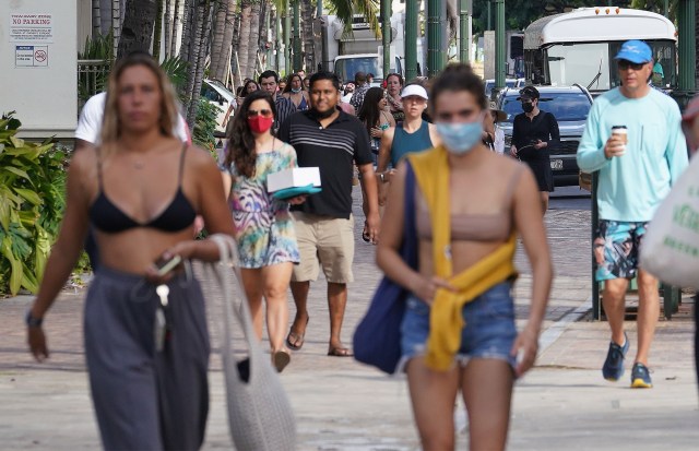 Visitors using masks and unmasked along Kalakaua Avenue as visitor arrivals increase to Hawaii during the COVID-19 pandemic.