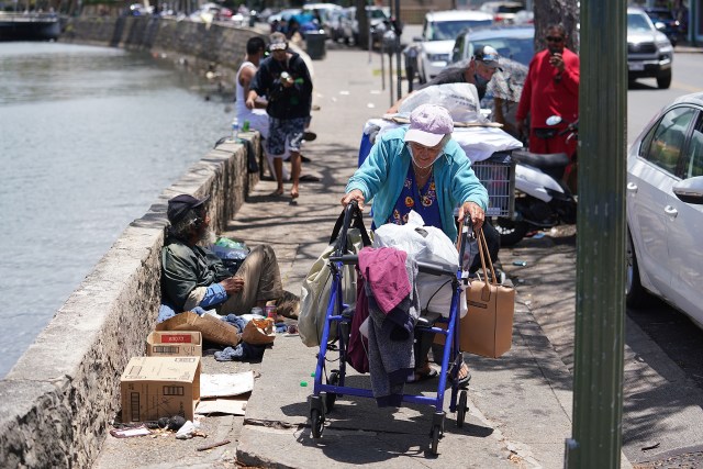 People gather along River Street laying on cardboard and and makeshift living areas.