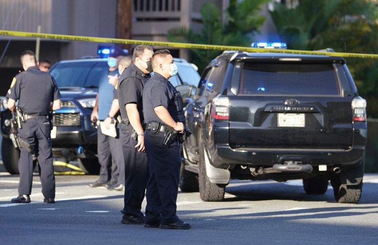 Honolulu Police officers stand at shooting scene at the intersection of Philip Street and Kalakaua Avenue. April 5, 2021