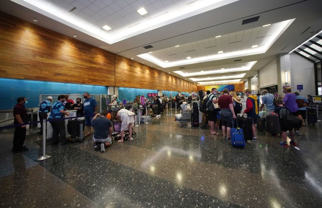 Scores of travelers check into interisland and domestic US flights at the Hawaiian Airlines check in area located at the Daniel K. Inouye International Airport during the COVID-19 pandemic.
