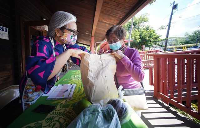 Kokua Kalihi Valley staff member left, Stella Jacinto prepares some food/supplies for right, Estrelia Maduli at the Kokua Kalihi Valley Comprehensive Family Services building.