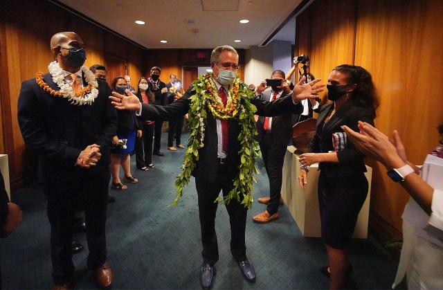 Senator J. Kalani English House is greeted by House members waiting to go into the Senate chambers.