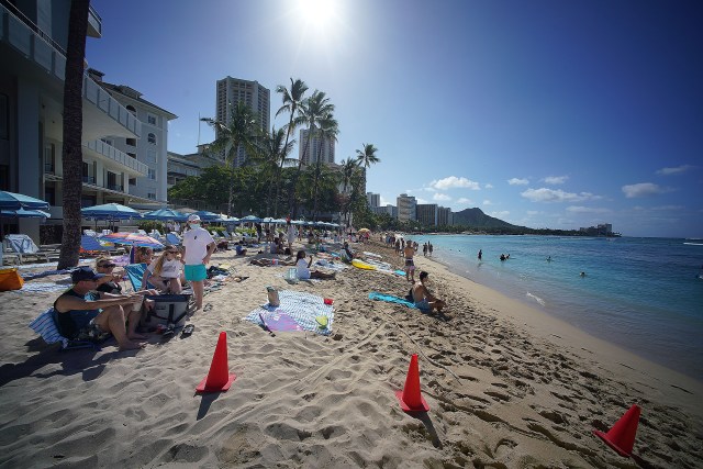 Visitors lounge on the shores of Waikiki Beach during the COVID-19 pandemic.