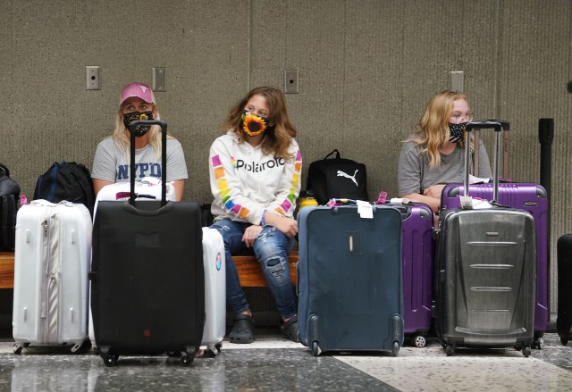 Passengers seated in the luggage area at Daniel K. Inouye International Airport.