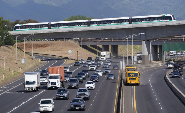 The HART rail train travels along the guideway near the H1/H2 freeway merge near Leeward Community College.