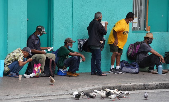 Patrons eat lunch outside the River of Life Mission located on Pauahi Street in Chinatown.