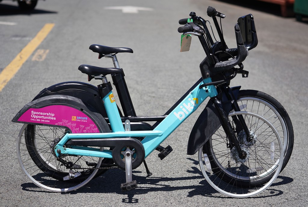 Biki bike that was vandalized with a large dent in the downtube.