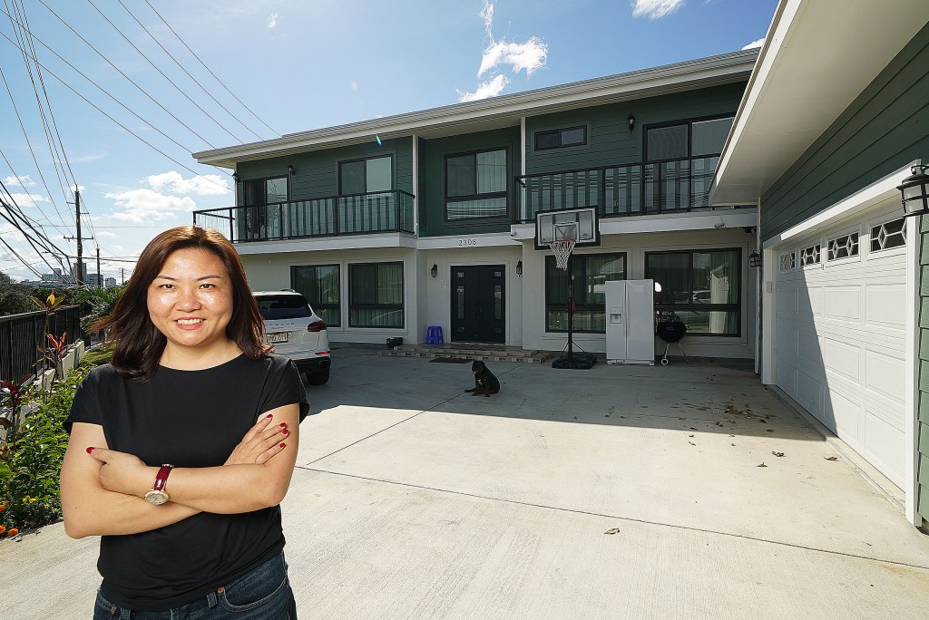 Christy Zeng Lei stands fronting one of houses she owns located at 2308 Dole Street.