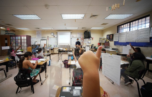 A student raises their thumb at Holomua Elementary School in Mr. Suan's 4th grade class.