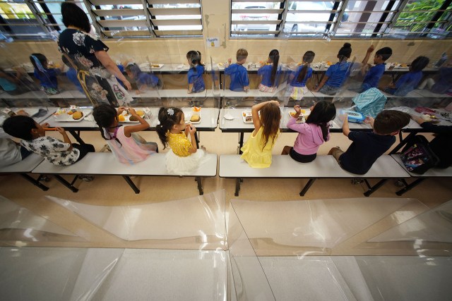 Holomua Elementary School students enjoy lunch with plastic barriers during the COVID-19 pandemic.